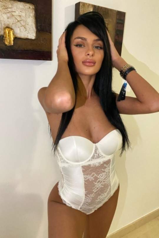 Sofia wearing a white and see-through one-piece.